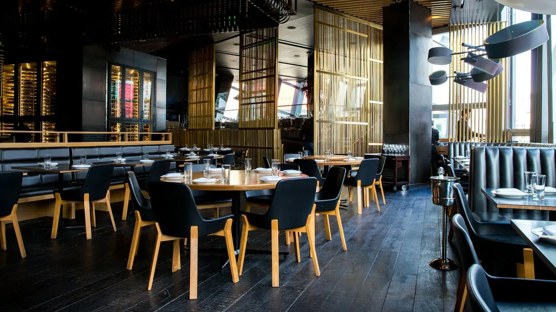 Sfeervol restaurantinterieur met gedekte tafels en warme verlichting.
